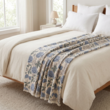 Bedroom with a bed featuring a floral-patterned blanket and white bedding.