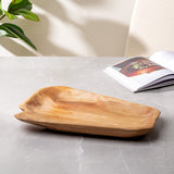 Wooden platter platter that was hand-carved from fir stumps left by logging industry on a gray surface with a magazine and plant in the background