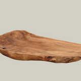 Wooden platter platter that was hand-carved from fir stumps left by logging industry on a beige background.