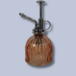 Vintage-style brown glass atomizer with chrome top on a light gray background