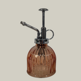 Vintage-style brown glass atomizer with chrome top on a light gray background