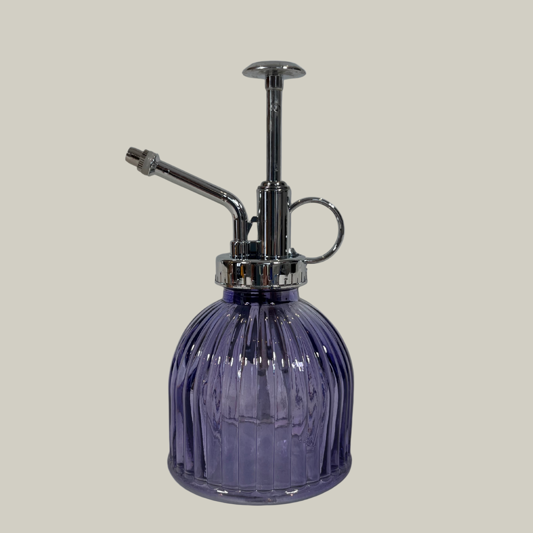 Purple glass spray bottle with silver nozzle on a light gray background