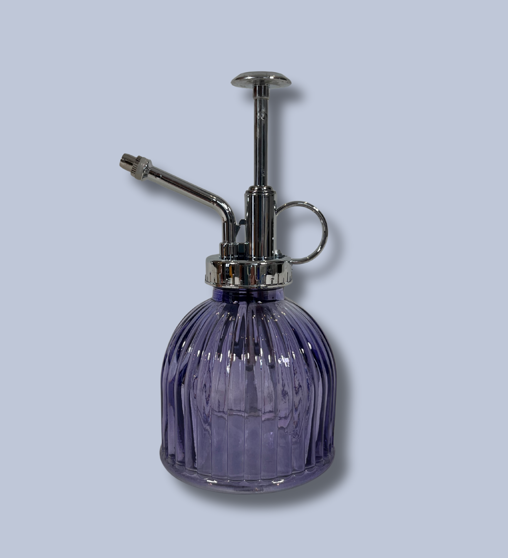 Purple glass spray bottle with silver nozzle on a light gray background