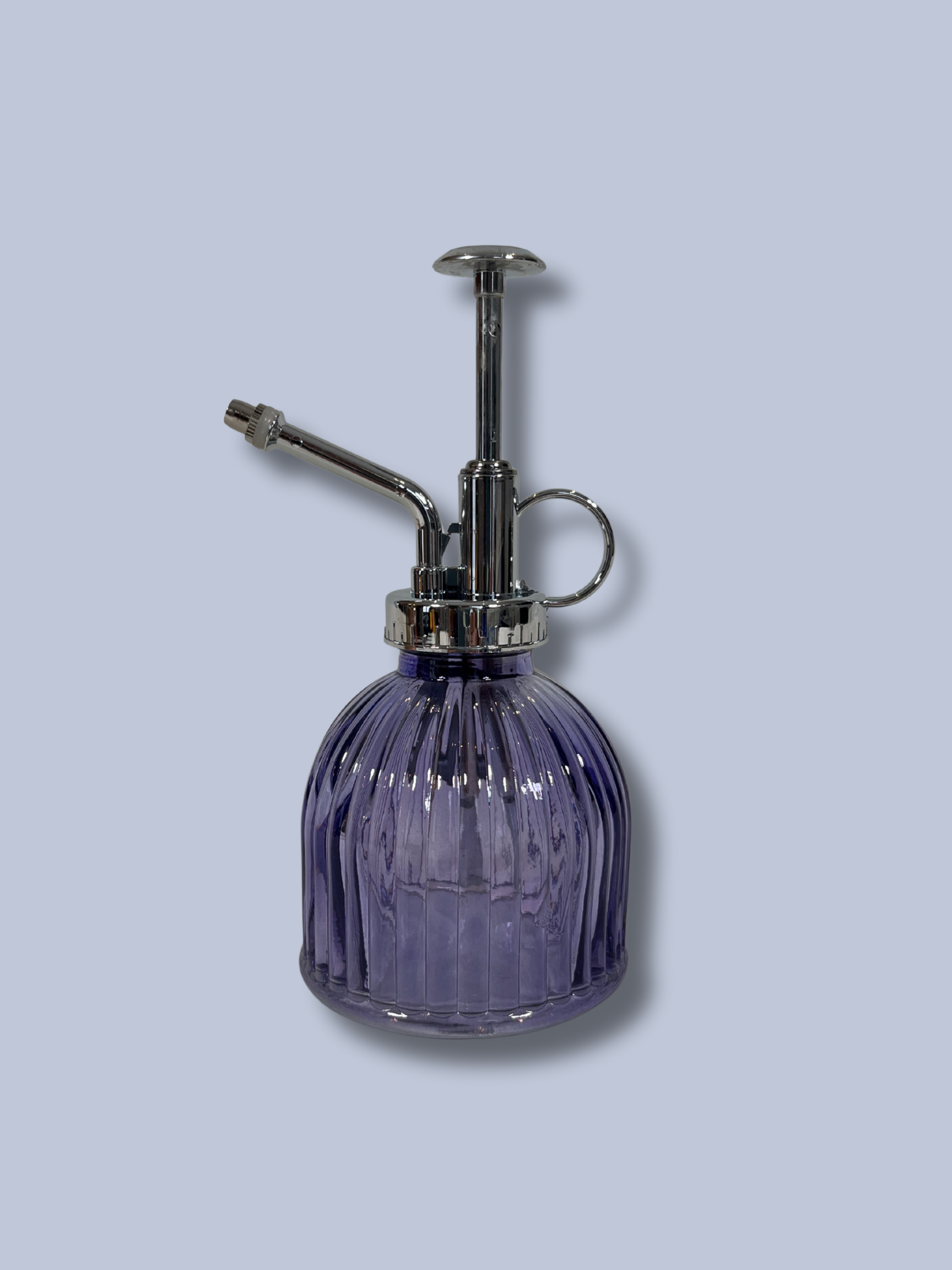 Purple glass spray bottle with silver nozzle on a light gray background