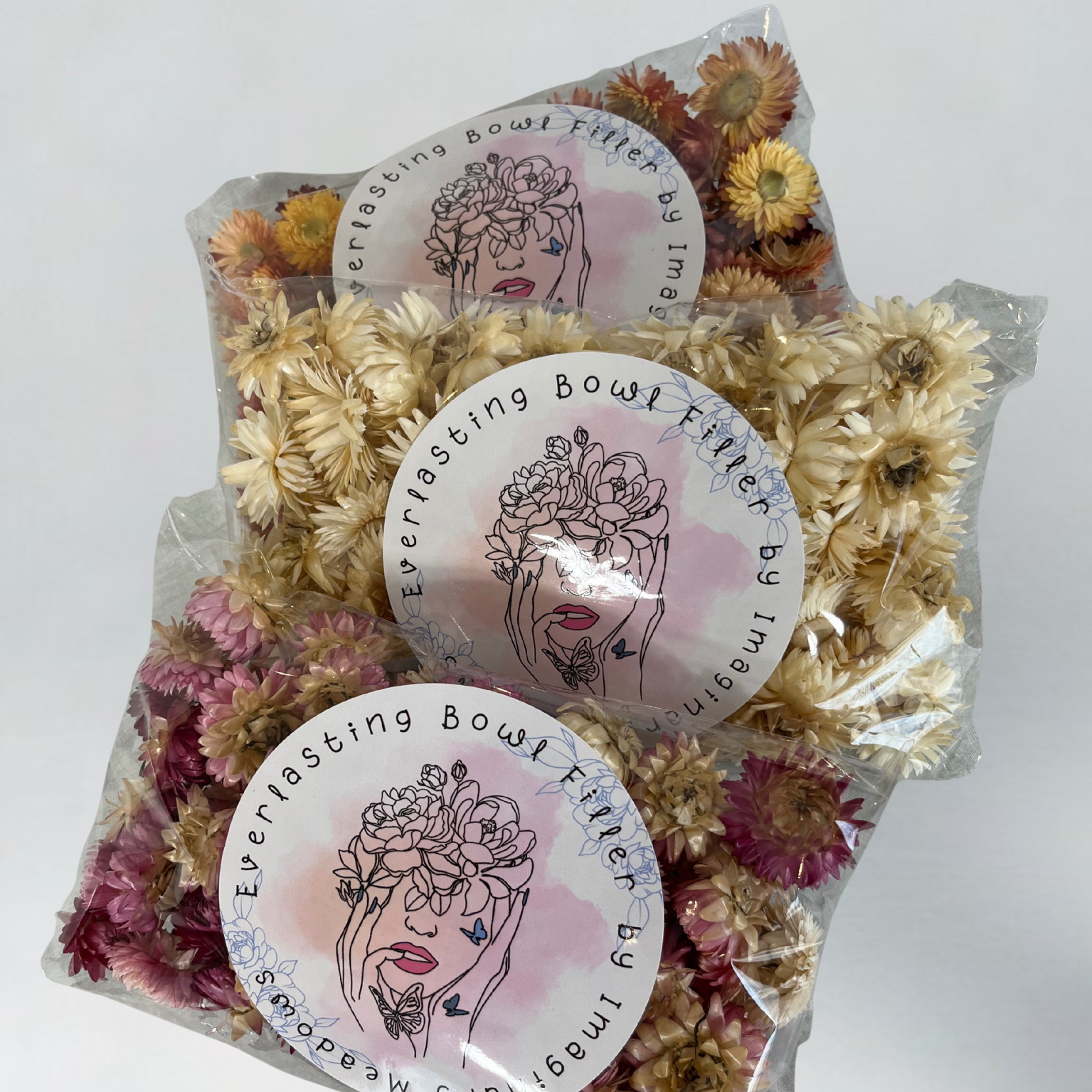 Packages of Hellicrysum floral heads to be used as an everlasting bowl filler In a plastic bag with floral design.