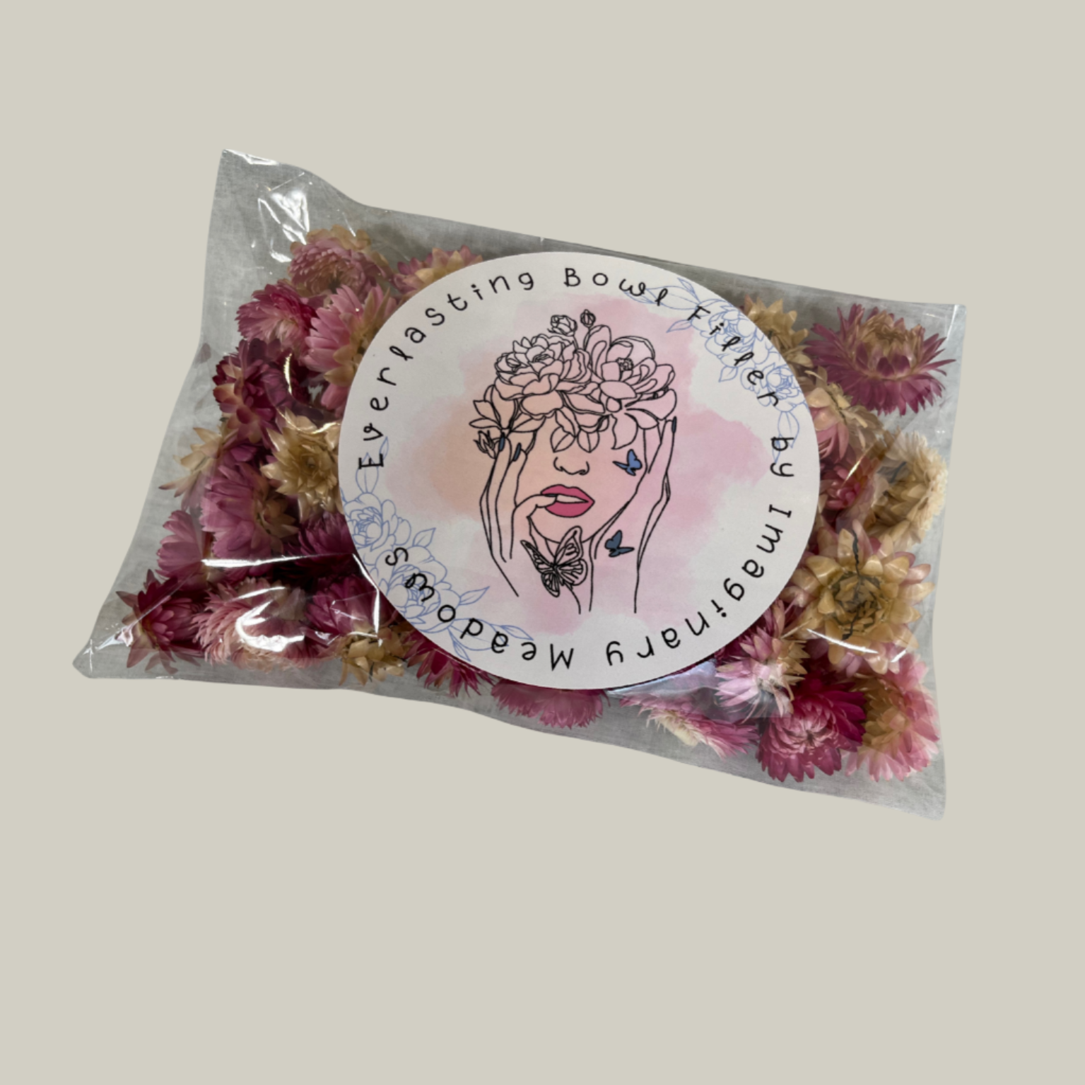 Package of natural pink Hellicrysum floral heads to be used as an everlasting bowl filler In a plastic bag with floral design.