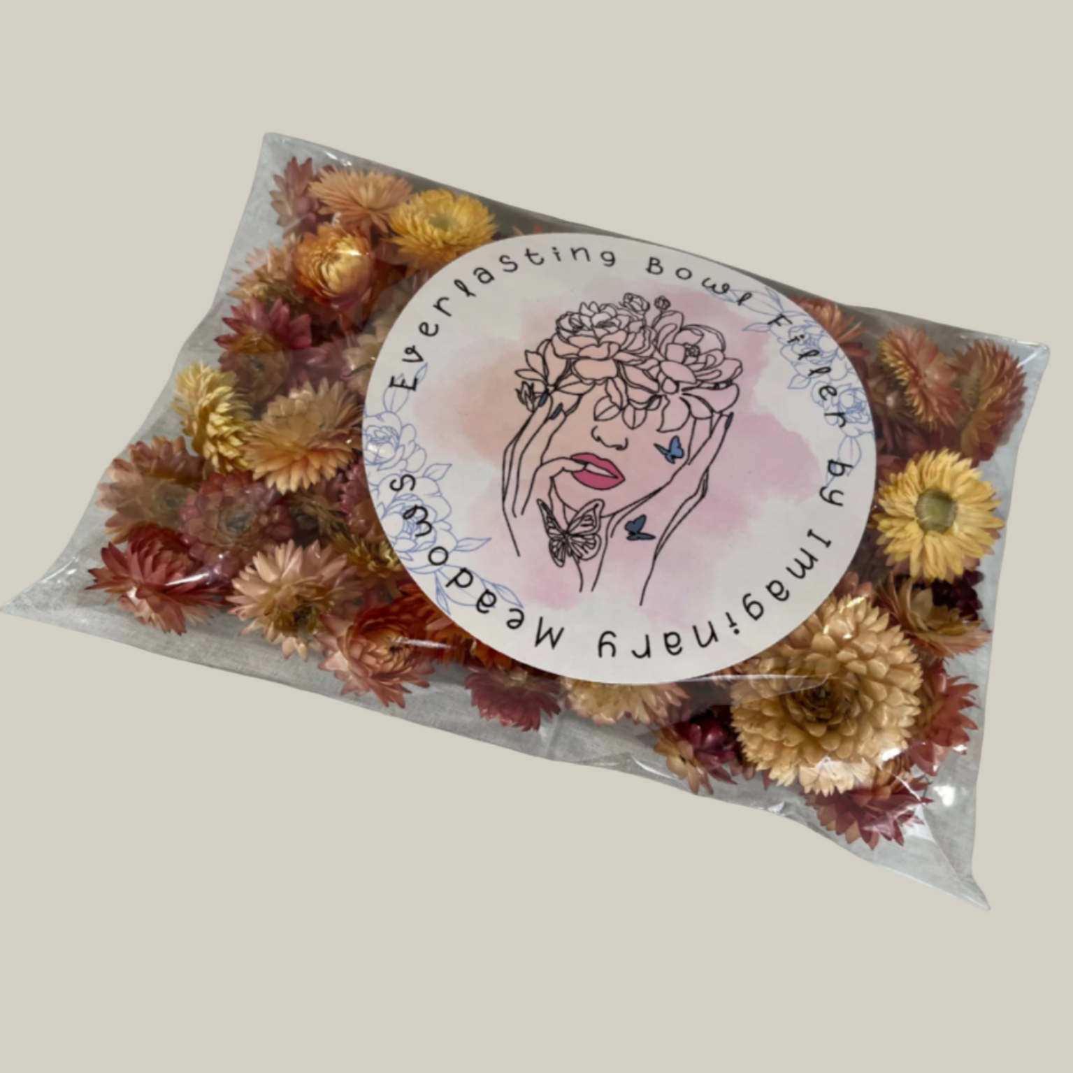 Package of natural salmon coloured Hellicrysum floral heads to be used as an everlasting bowl filler In a plastic bag with floral design.