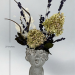 Decorative concrete vase with everlasting floral arrangement on a gray background