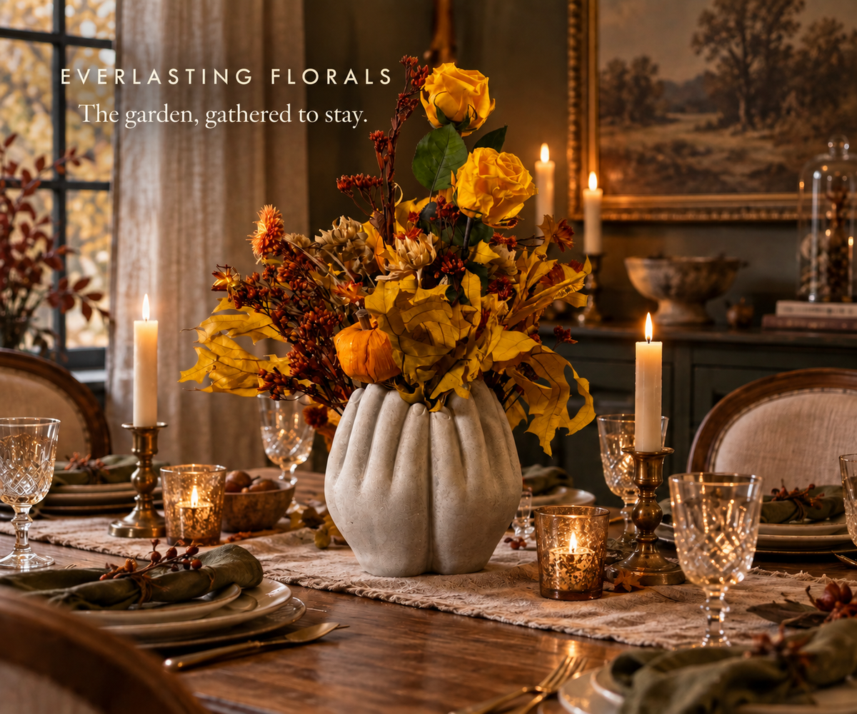 A floral arrangement in the centre of a dining table set for dinner.