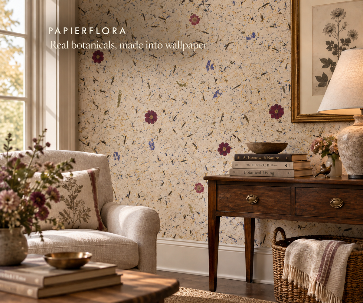 Living room featuring real botanical wall coverings, with a cream chair and wood console as furnishings.