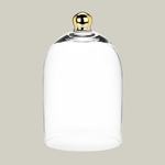 Clear glass cloche with a gold handle on a beige background 2
