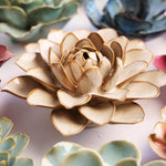 Decorative ceramic Dahlia sculpture surrounded by other ceramic flower sculptures. 