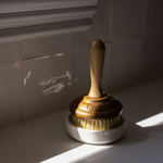 Wooden dish brush with bristles in a marble holder on a light surface. 3