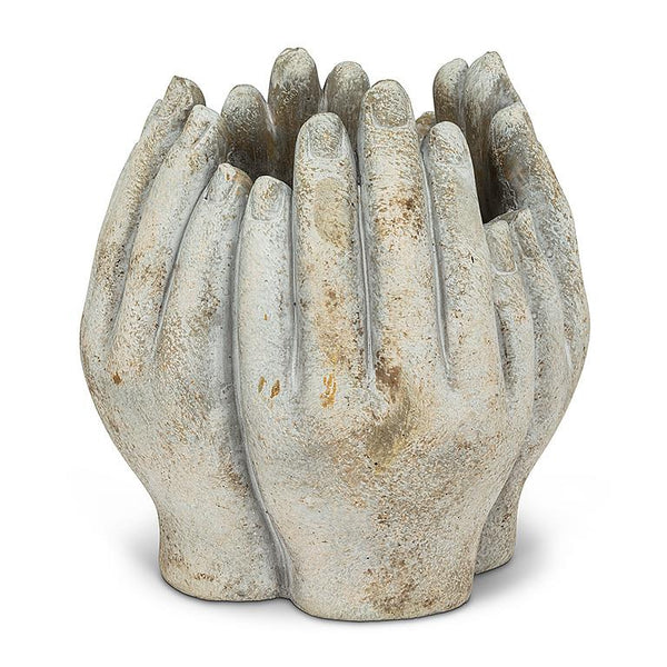 Concrete vase carved into four hands in a circle on a white background.