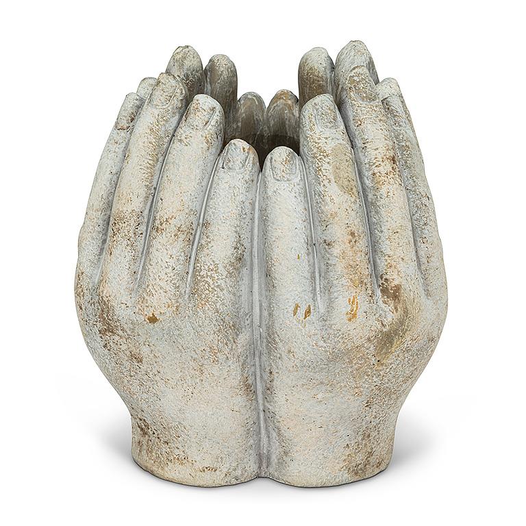 Concrete vase carved into four hands in a circle on a white background.
