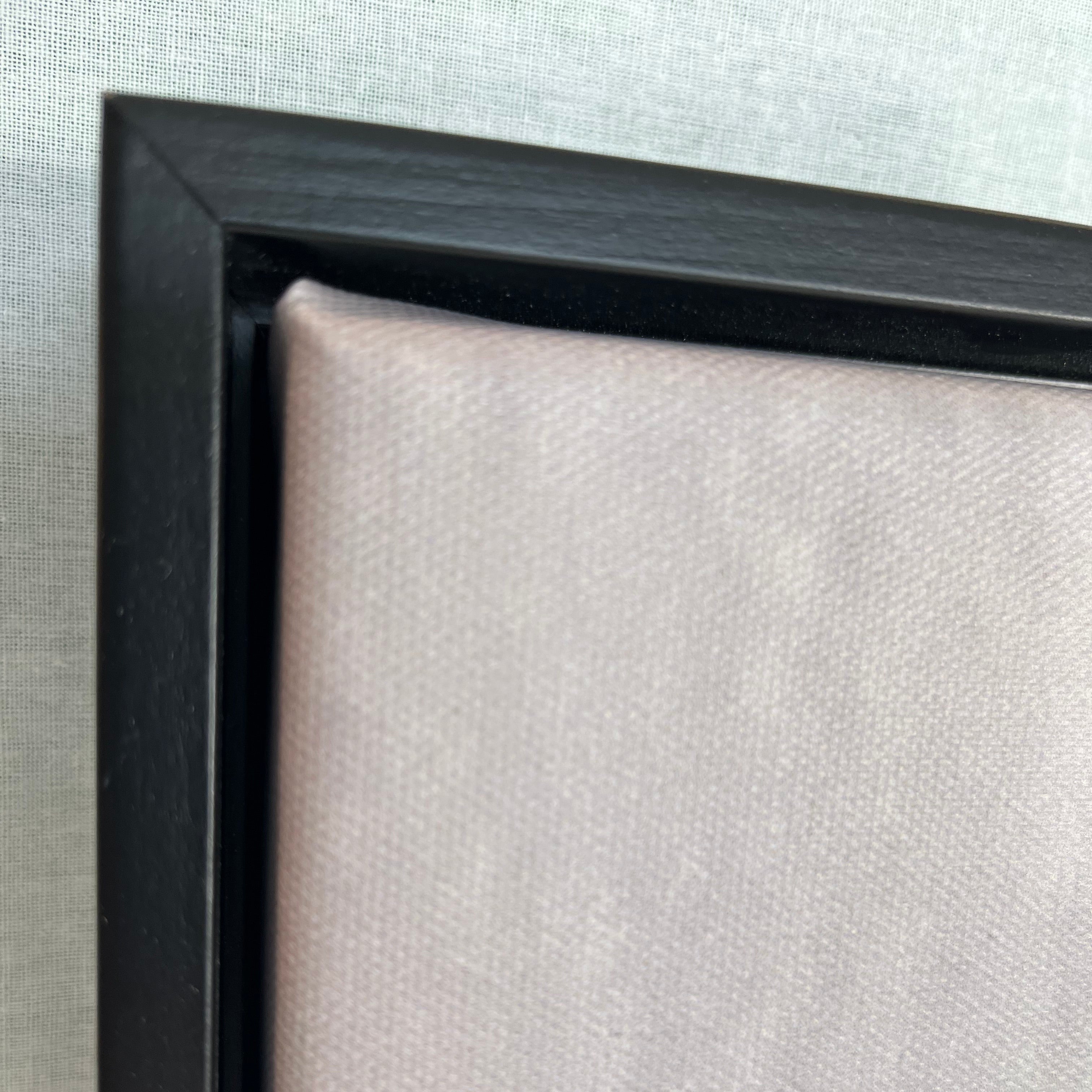 Close-up of a black picture frame corner on a light gray background