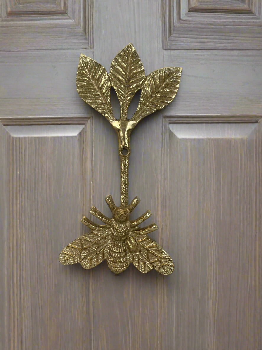 Brass bee-shaped hook on a wood door