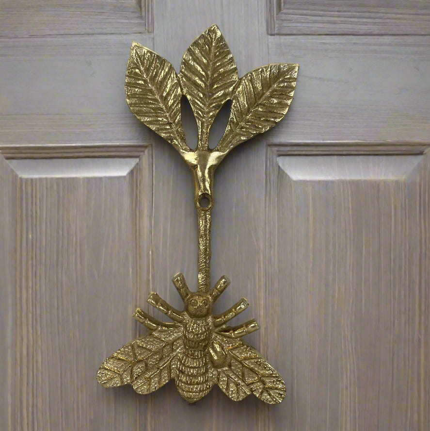 Brass bee-shaped hook on a wood door