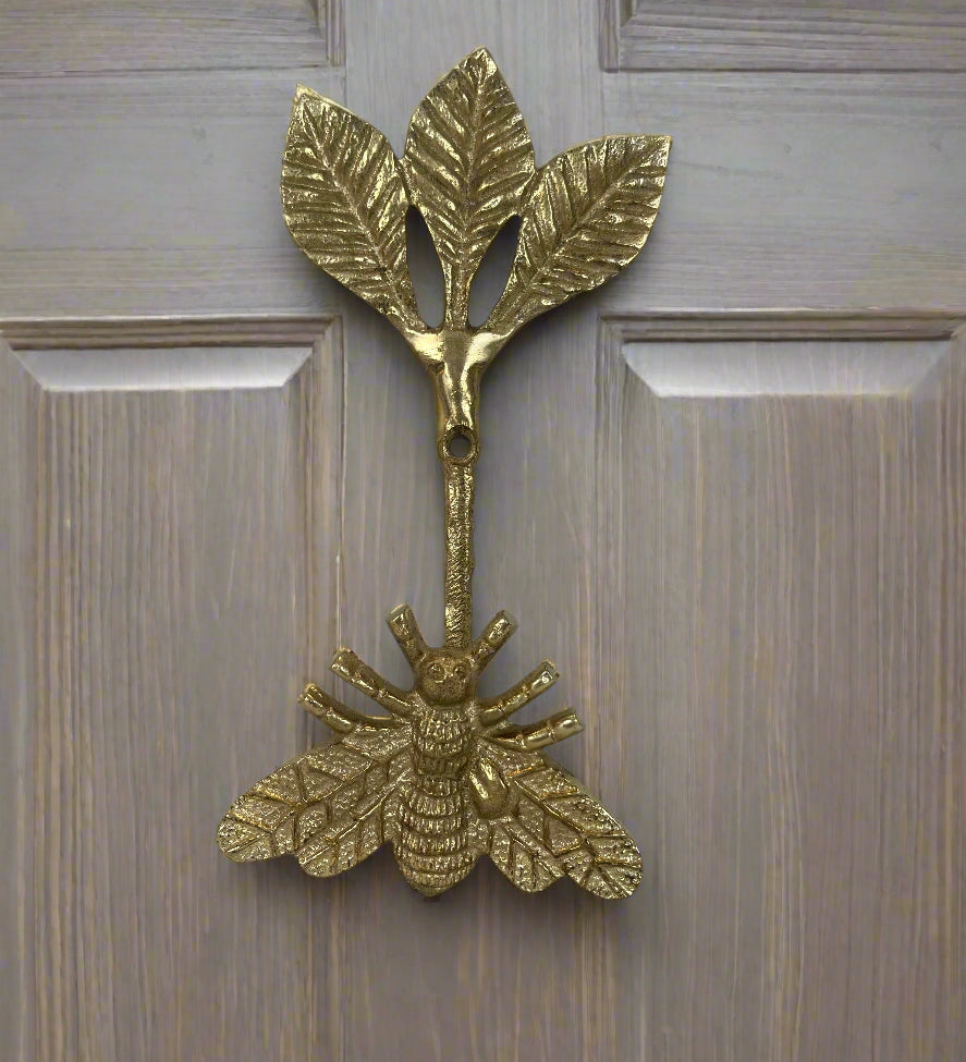 Brass bee-shaped hook on a wood door