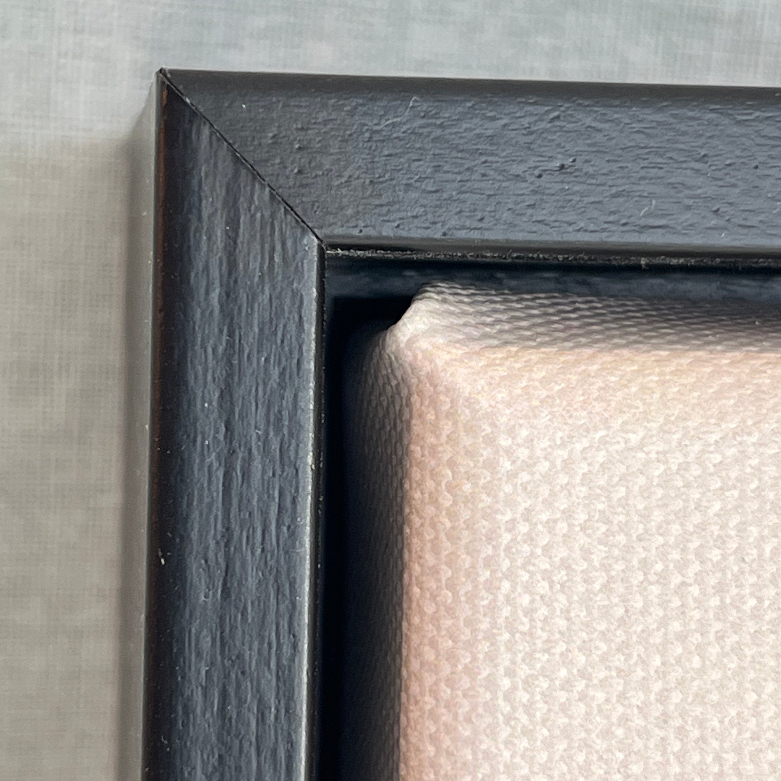 Close-up of a black picture frame corner on a textured gray background