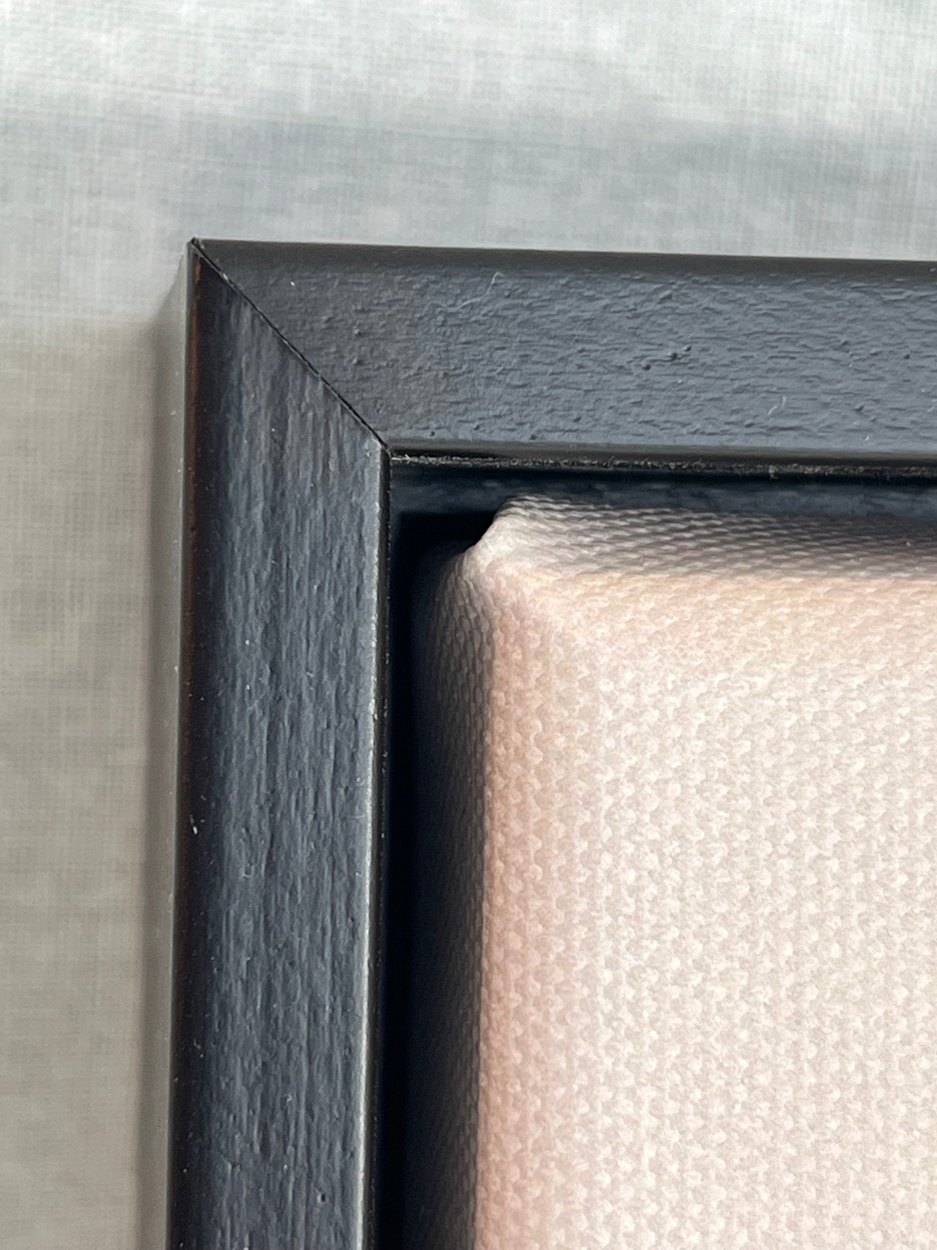 Close-up of a black picture frame corner on a textured gray background