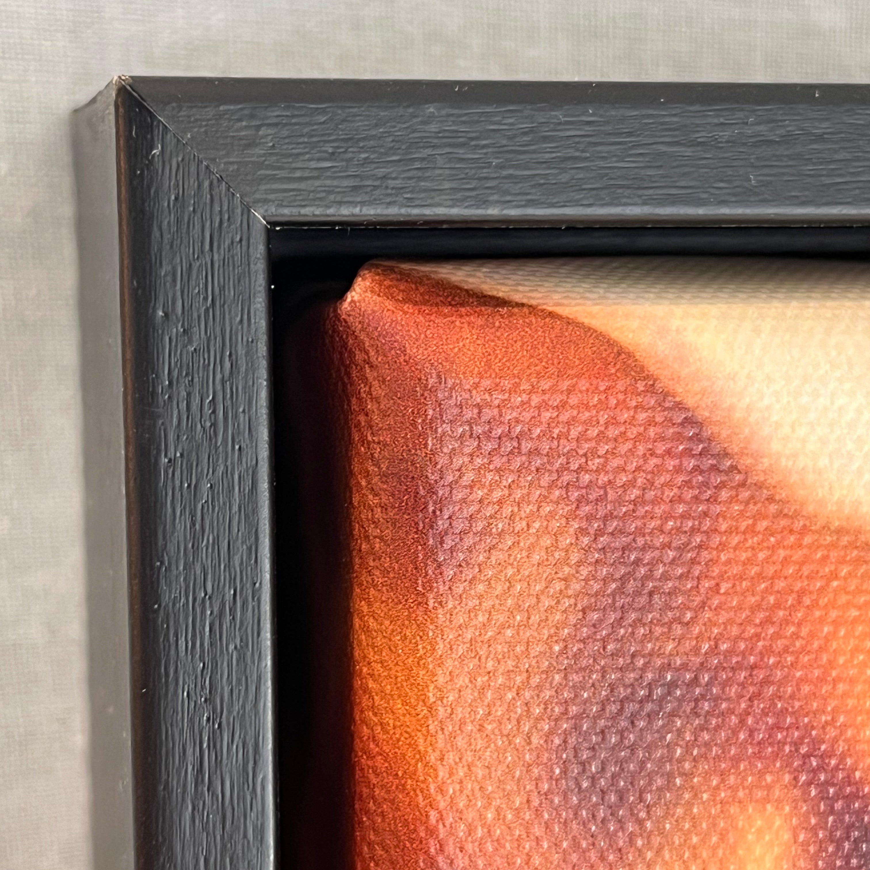 Close-up of the corner details of a photograph with a textured surface and black frame.
