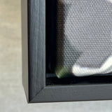 Close-up of a black framed photography on a textured gray background