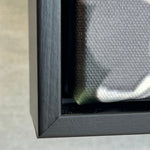 Close-up of a black framed photography on a textured gray background 3