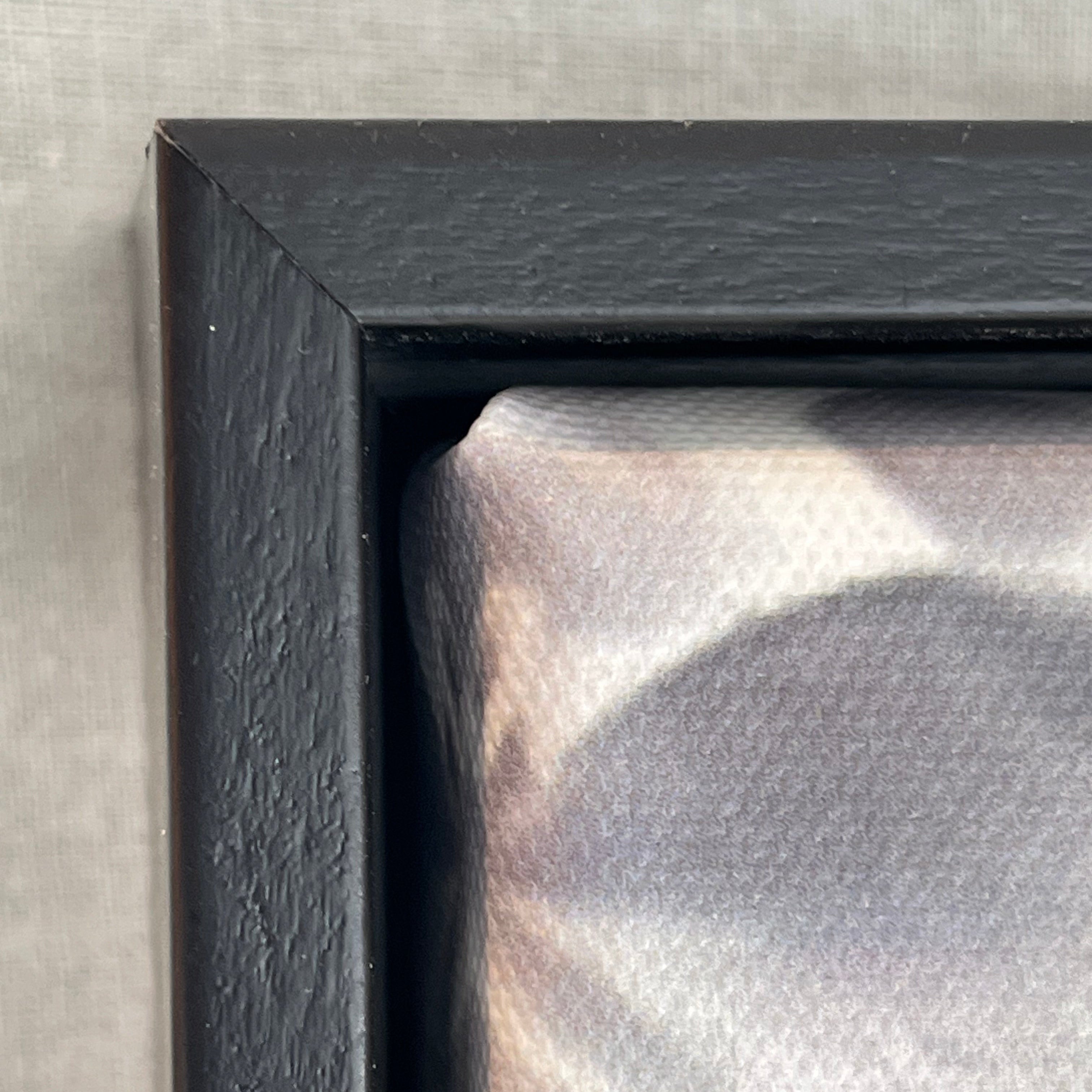 Close-up of a black frame corner on a textured surface