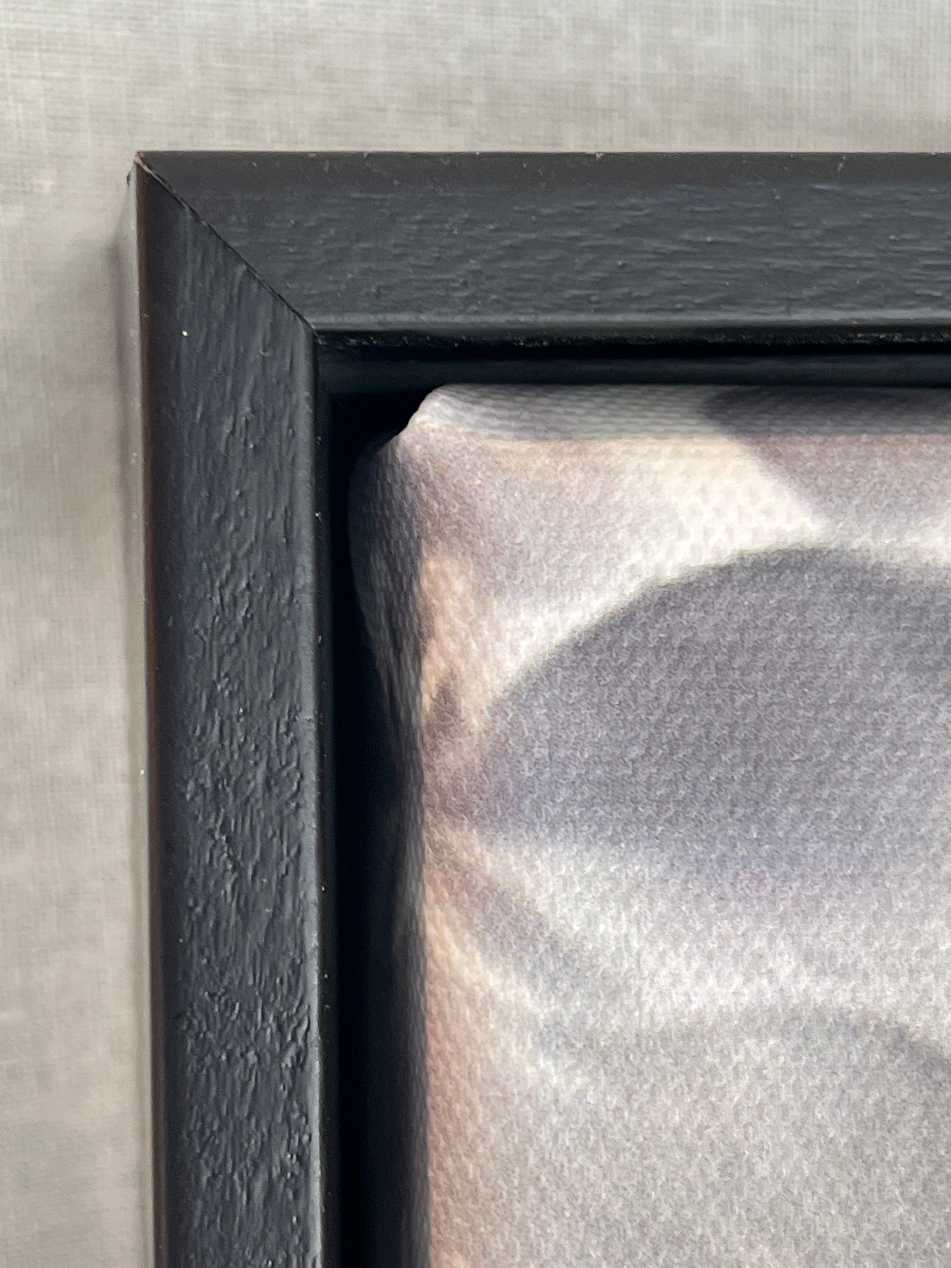 Close-up of a black frame corner on a textured surface