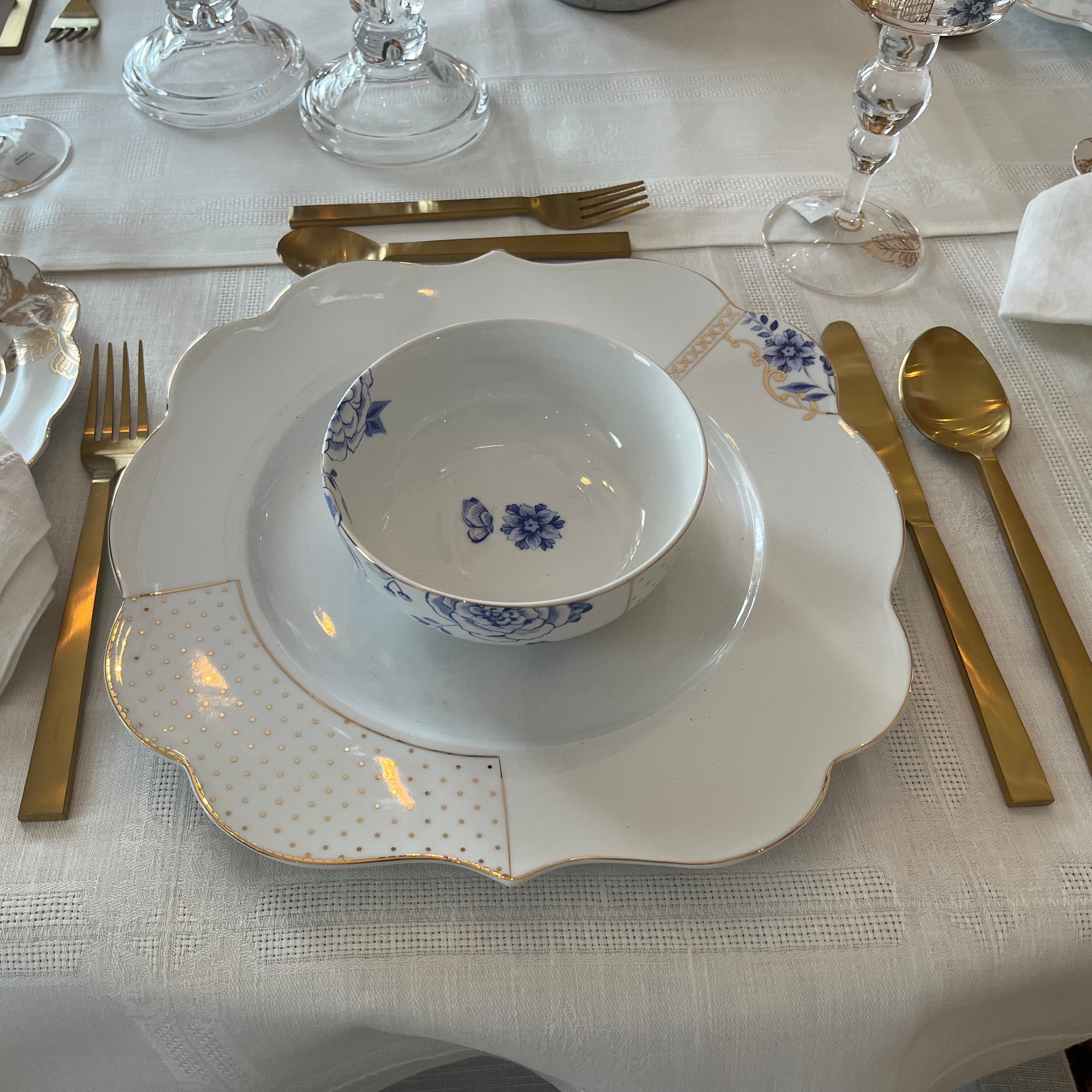 A table setting featuring our Royal White dishes and the gold plated stainless steel flatware set including 2 forks, 2 spoons, and 1 knife.
