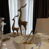 Two gold reindeer silhouette figurines on a dining featured as a centrepiece. 