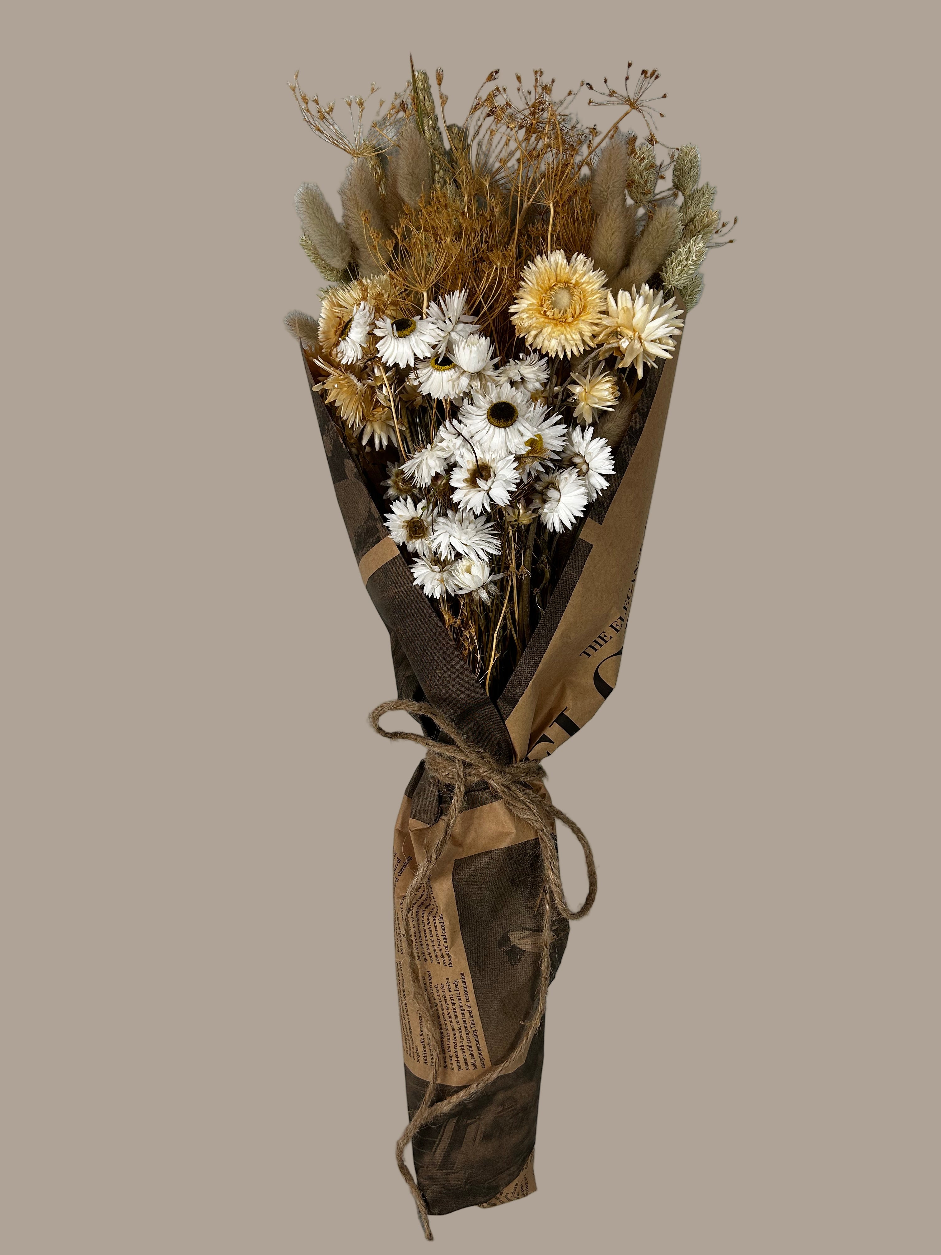 This striking, hand-tied bouquet is a harmonious blend of dried botanicals in deep red, soft pink, and natural oats, carefully curated and wrapped in a polished rendition of classic vintage newspaper. 