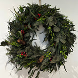 A wreath featuring a stunning foundation of deep green preserved spruce and preserved boxwood, beautifully layered with the modern forms of dried green curly eucalyptus and large round leaf eucalyptus. Traditional accents of red berries and natural pinecones are nestled throughout, completing this breathtaking tapestry of texture and colour.
