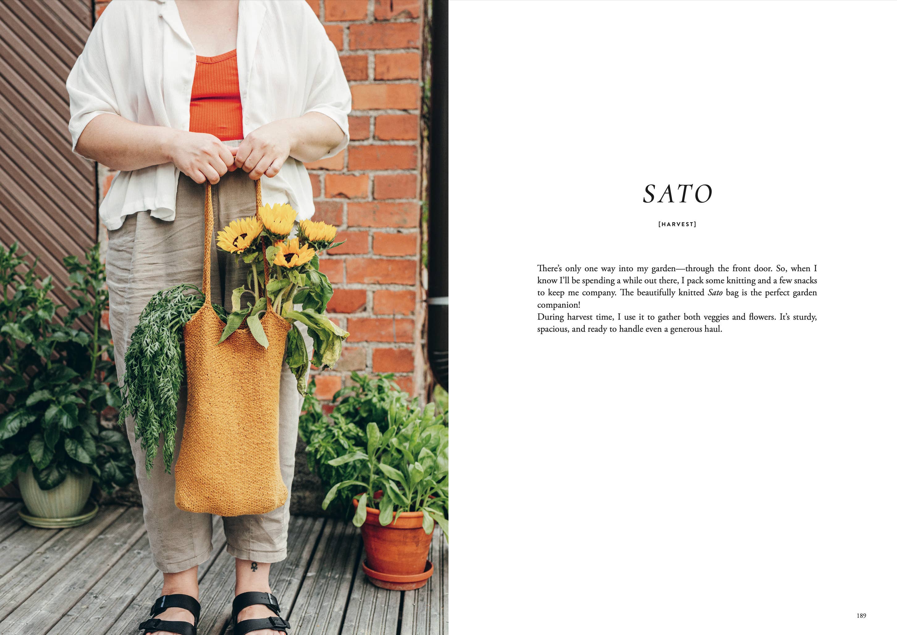 Person holding a yellow tote bag with plants, standing next to a brick wall.