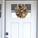 10-inch wreath made with lush purple Statice, creamy natural strawflowers, feathery bunny tails, delicate Larurus ovatus, and graceful natural oat grass on a white door with a window.