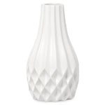 A white ceramic vase with a fluted, ribbed body and a faceted diamond-patterned base, shown against a plain white background.