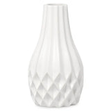 A white ceramic vase with a fluted, ribbed body and a faceted diamond-patterned base, shown against a plain white background.