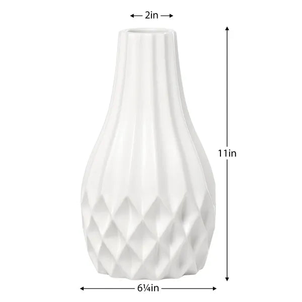 White ceramic vase with a fluted neck and faceted textured base, shown with dimension labels indicating 2 in top diameter, 11 in height, and 6 4/5 in base diameter.