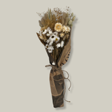 Hand-tied bouquet that is densely populated with ethereal natural white rhodanthe, subtle bupleurum, soft helichrysum vestitum, and graceful phalaris. Complemented by the rustic charm of natural wheat, and the playful softness of lagurus ovatus. It’s a symphony of creamy whites and earthy textures. 