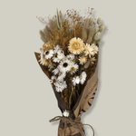 Hand-tied bouquet that is densely populated with ethereal natural white rhodanthe, subtle bupleurum, soft helichrysum vestitum, and graceful phalaris. Complemented by the rustic charm of natural wheat, and the playful softness of lagurus ovatus. It’s a symphony of creamy whites and earthy textures. 