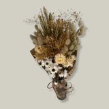 Hand-tied bouquet that is densely populated with ethereal natural white rhodanthe, subtle bupleurum, soft helichrysum vestitum, and graceful phalaris. Complemented by the rustic charm of natural wheat, and the playful softness of lagurus ovatus. It’s a symphony of creamy whites and earthy textures. 