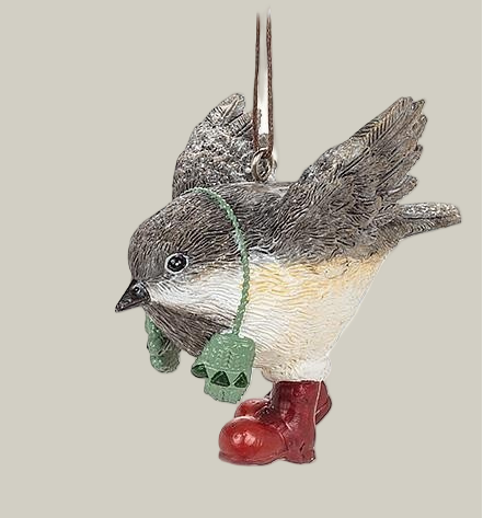 Decorative winter chickadee ornament wearing green mittens on a string around it's neck and red boots on a pale green background