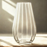 Clear glass vase on a wooden surface with soft lighting
