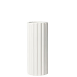 A tall cylindrical vase, whose silhouette is softened by delicate vertical ribbing, creating subtle movement as light shifts across its glossy white surface. 