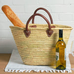Rustic yet elegant handwoven basket, embodying traditional French charm. Perfect for carrying your market treasures with ease; the sturdy yet supple leather handles provide both durability and a touch of effortless style. In this picture the basket is shown with bread and wine bottle. 2