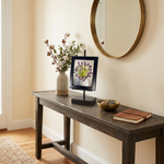 Console table with decorative items in a room with a mirror on the wall.