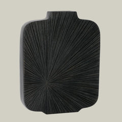 Side angle view of a striking, sculptural tall vase in midnight-cocoa with a bold, radiating carved pattern that starting in the bottom left corner. 