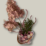 Decorative arrangement of flowers in a glass vase on a light gray background