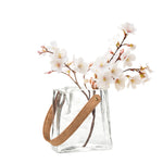 6.5 Inch tall clear glass vase shaped like a paper bag with faux leather holding white flowers.